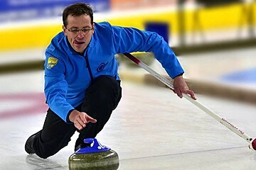 a man throwing a curling stone