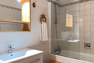 A bathroom with a sink and a bottle of aesop on the counter