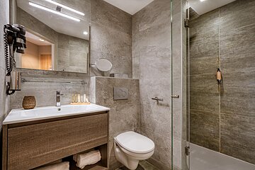 A bathroom with a toilet a sink and a mirror