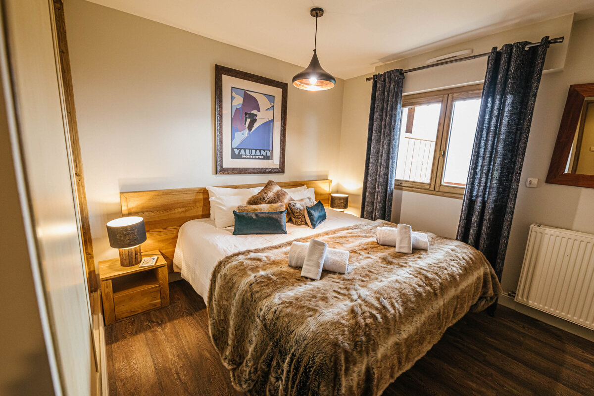 A bedroom with a bed and a picture on the wall that says valiano