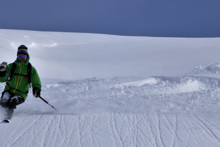 a skier in a green jacket