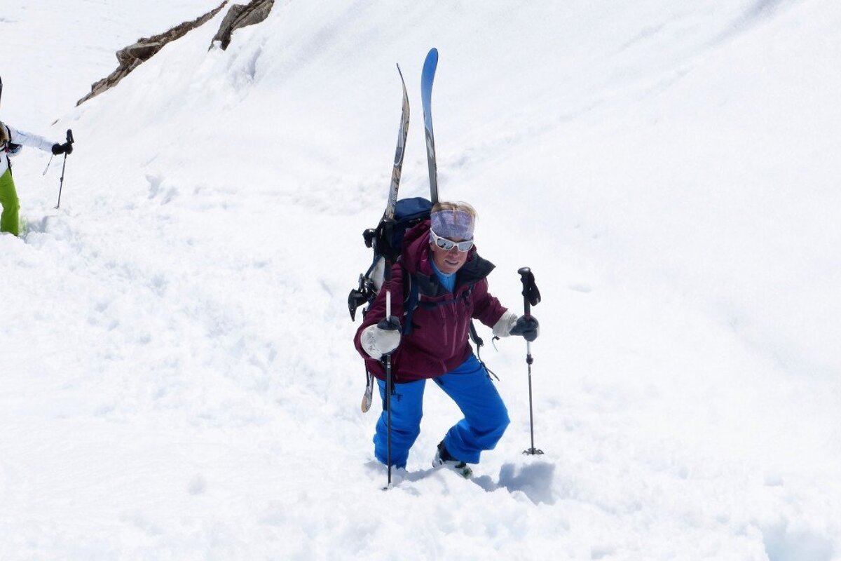 two skiers hiking up hill
