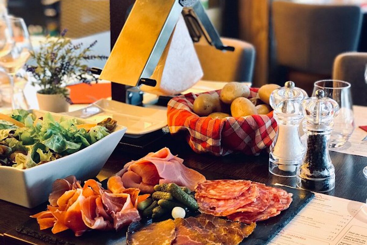 A tray of meats and vegetables sits on a table next to a menu