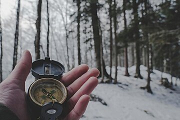 Compass to help with a treasure hunt in the snowy woods