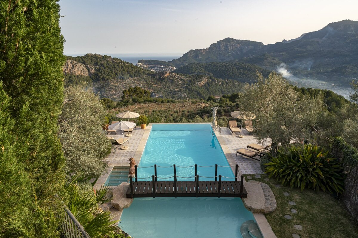 A large swimming pool with a wooden bridge over it