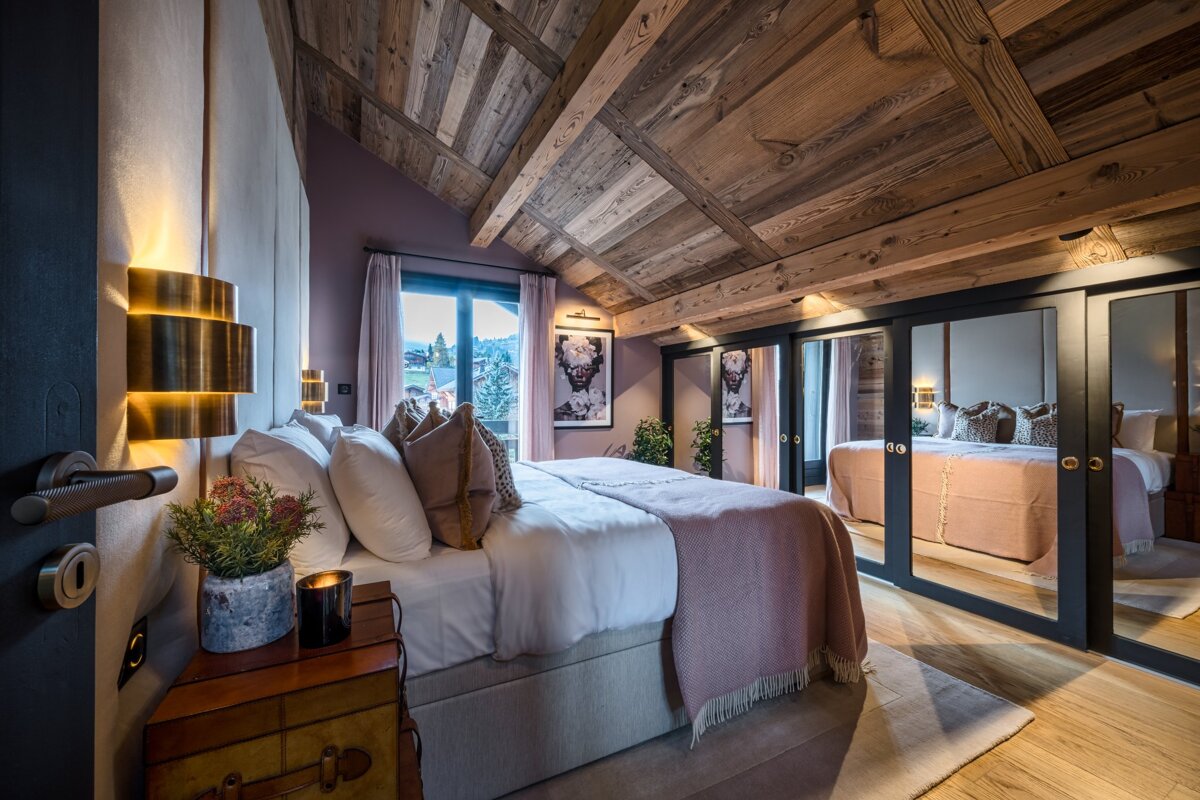 A bedroom with a wooden ceiling and a large bed