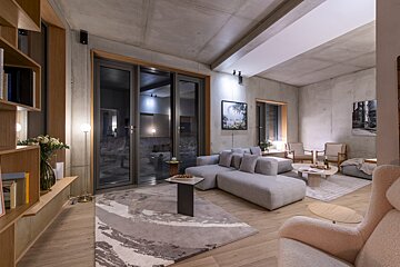 A living room with a couch and chairs and a rug