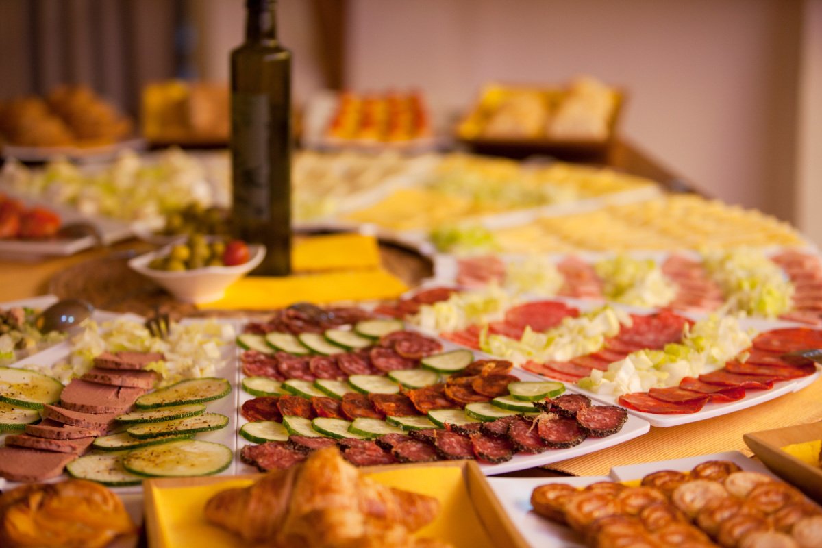 A buffet table with a bottle of olive oil in the background