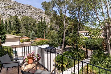 A balcony with a view of a mountain and trees