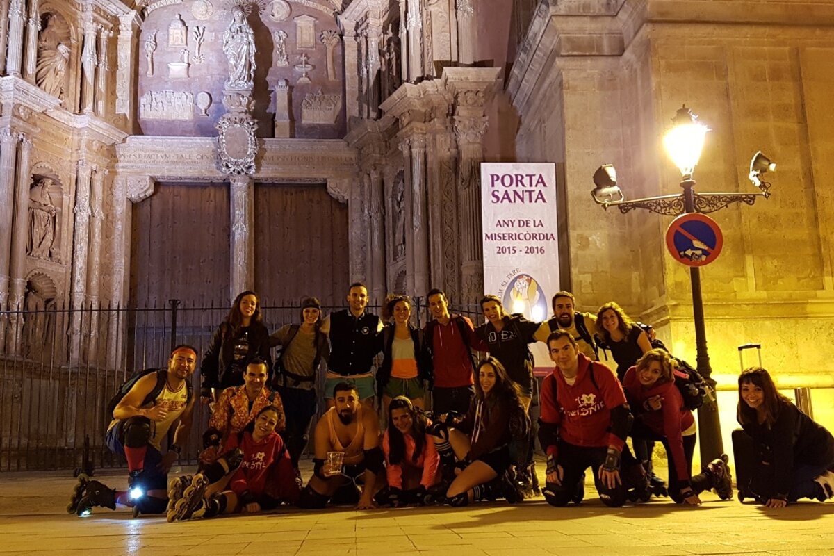 a group of roller skaters in front of a church in palma at night