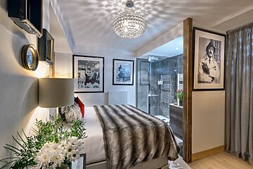 A bedroom with a bed and a picture of a man on the wall