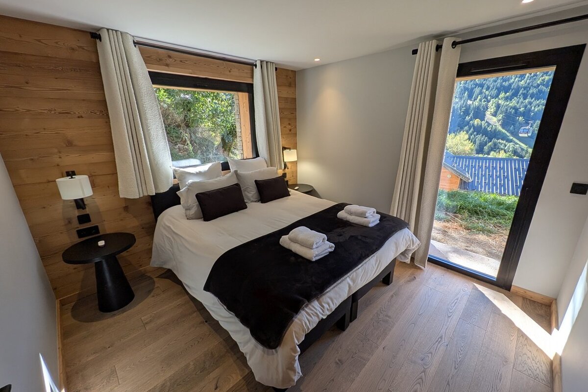 A bedroom with a large bed and a large window