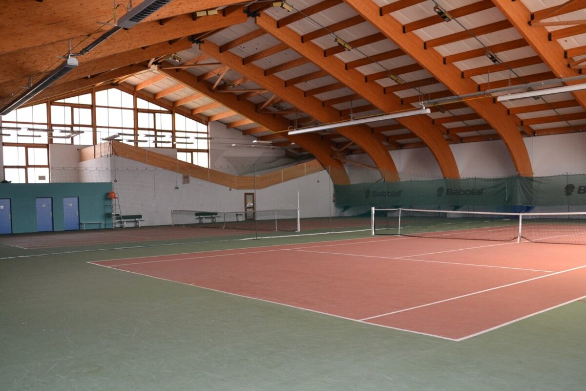 An indoor tennis court with a babolat net