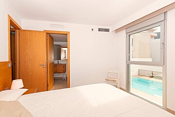 A bedroom with a view of a swimming pool