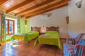 A bedroom with two beds a chair and a window