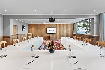 A conference room with a projector screen that says araucaria