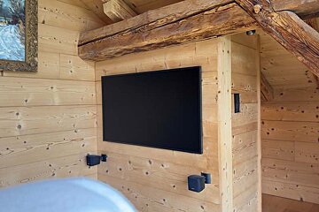 A flat screen tv is mounted on a wooden wall