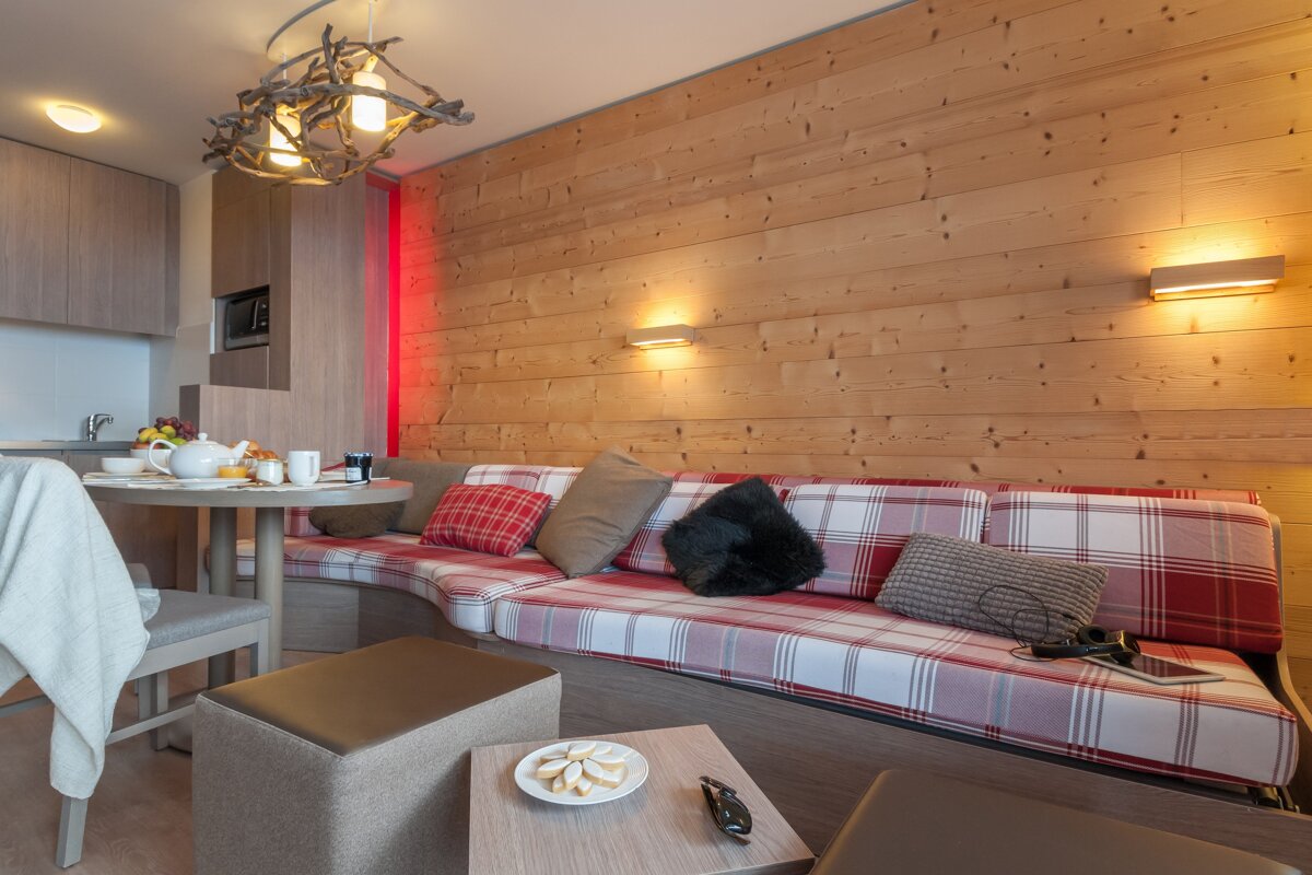 A living room with a couch and a table with a plate of cookies on it