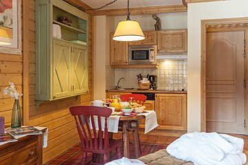 A kitchen with a table and chairs and a microwave