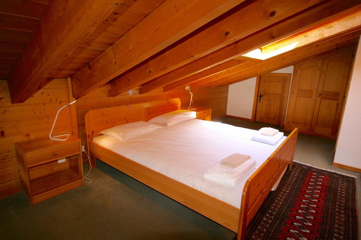 A bedroom with a king size bed and a nightstand
