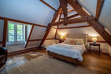 A bedroom with a bed and two lamps