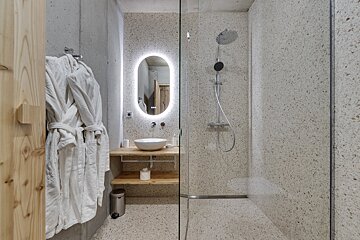 A bathroom with a walk in shower and a sink