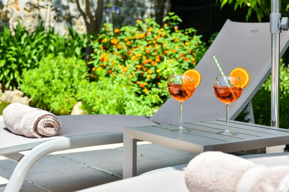 Two glasses of orange juice with straws on a table