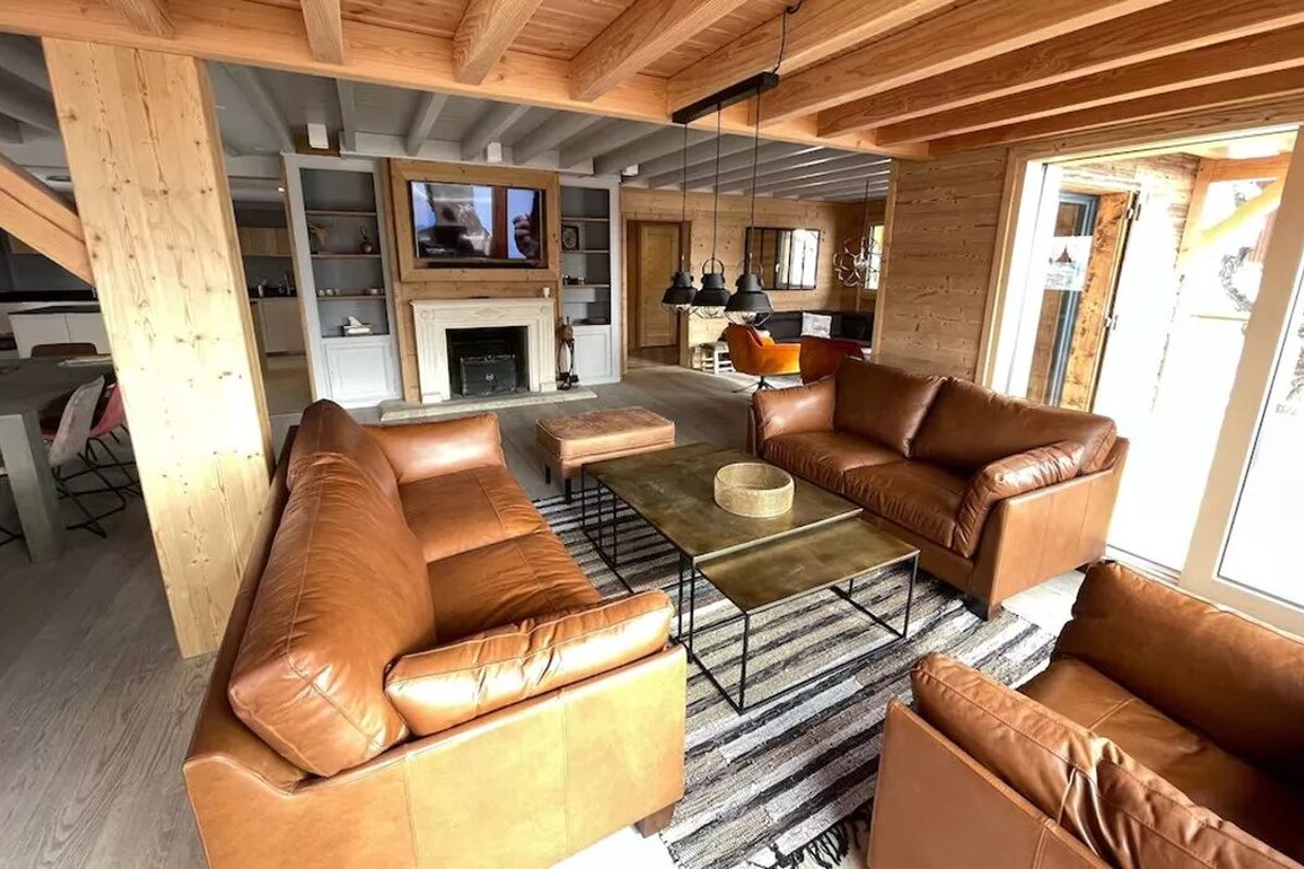 A living room with brown leather furniture and a fireplace