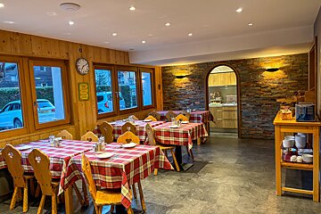 A restaurant with tables and chairs and a clock on the wall