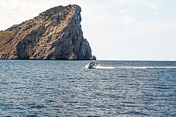 A boat in the ocean with a mountain in the background
