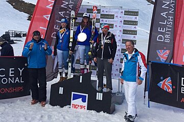 three people on the podium at a ski race