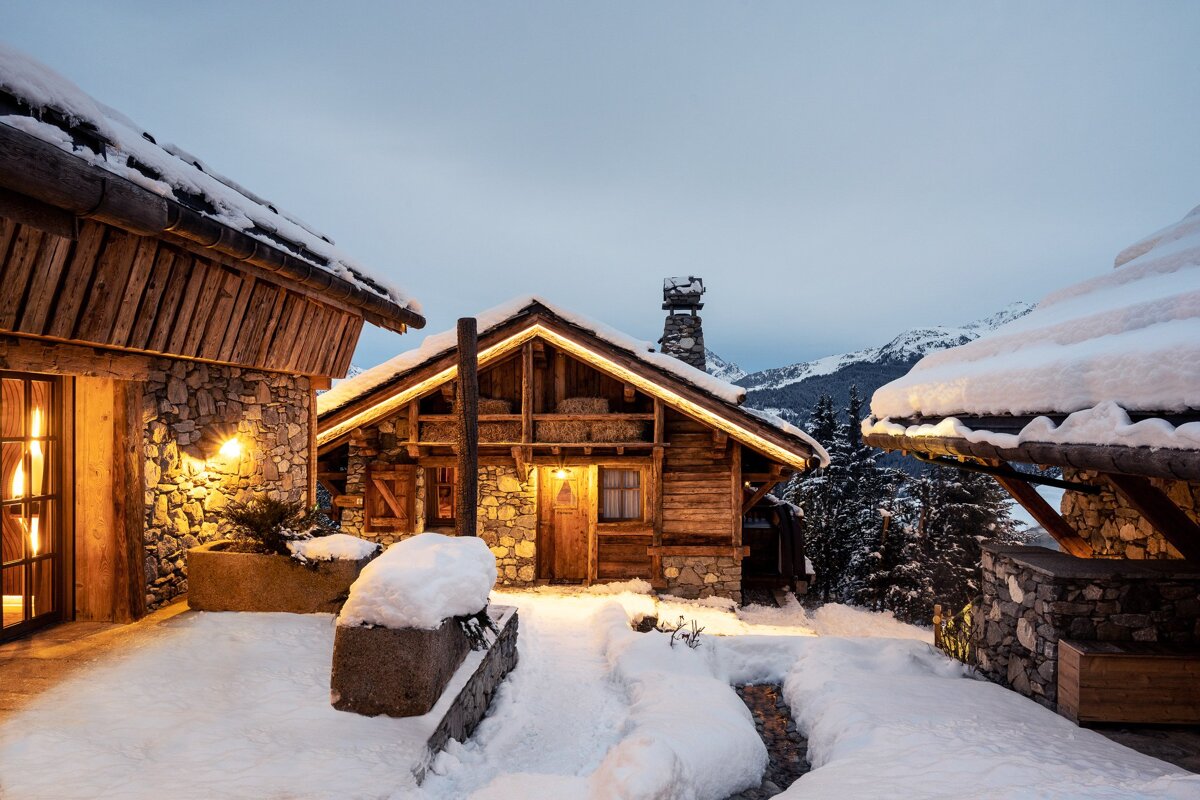 A snowy house with mountains in the background