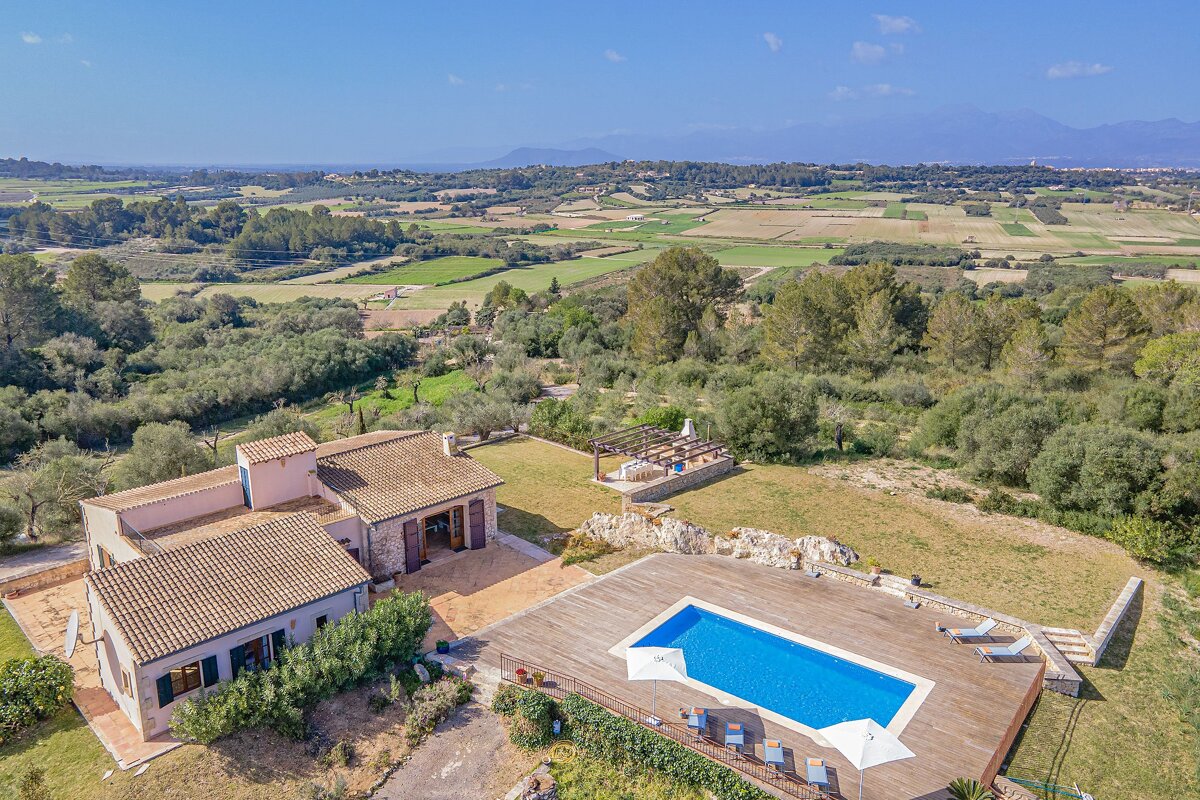 An aerial view of a house with a large swimming pool