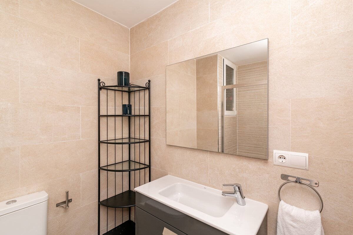 A bathroom with a sink a toilet and a mirror
