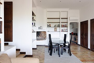 A living room with a table and chairs and a fireplace