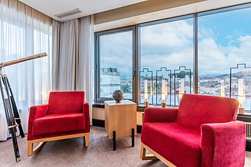 Two red chairs sit in front of a large window