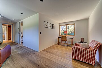 A room with a chair a desk and a window