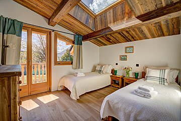 A bedroom with two twin beds and a skylight