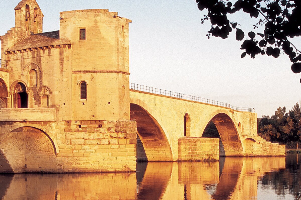 A bridge over a body of water with a building in the background