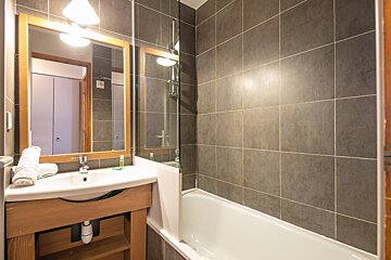 A bathroom with a sink a mirror and a bathtub