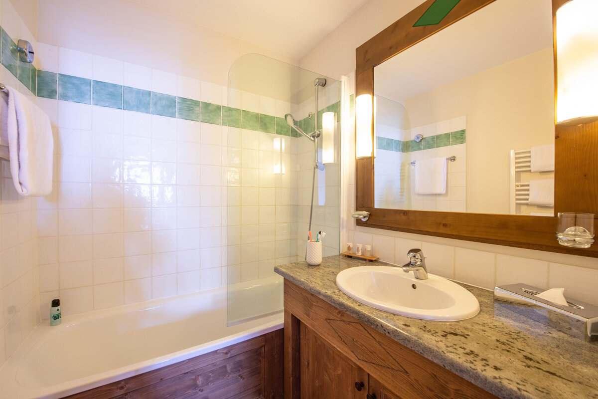 A bathroom with a sink a bathtub and a mirror