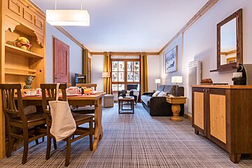 A living room with a couch a table and chairs