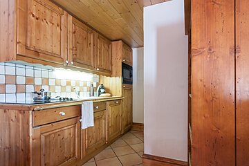 A kitchen with wooden cabinets and a stove top oven