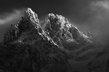 Black and white photo of snow dusted top of mountains in Chamonix