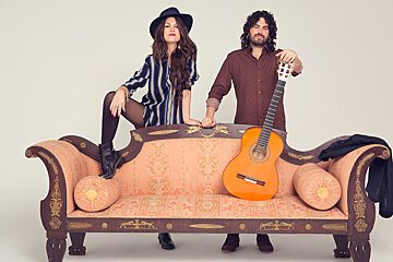 spanish singers behind a sofa