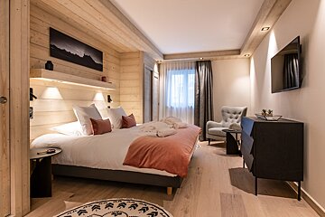 A bedroom with a large bed and a flat screen tv