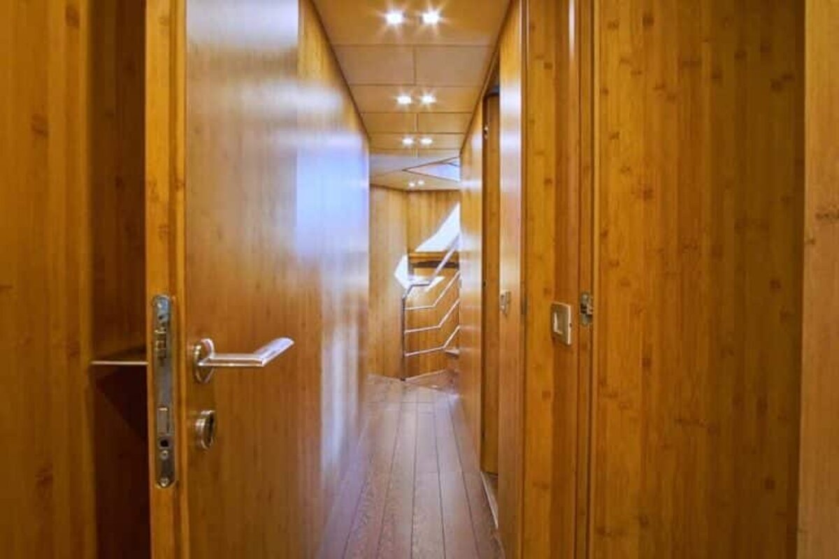 A hallway with wooden doors and stairs on a boat