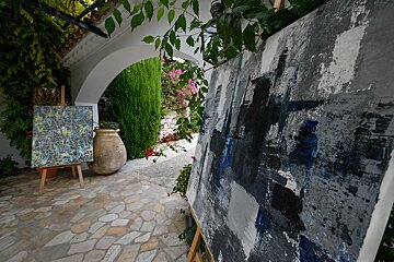 Two paintings are displayed on an easel outside