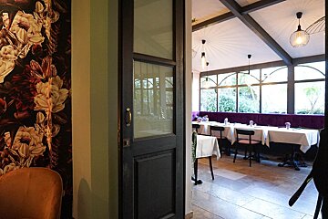 A dining room with tables and chairs and a floral wall