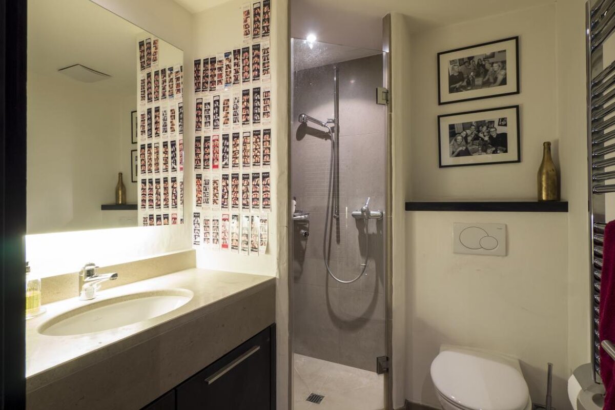 A bathroom with pictures on the wall and a sink and toilet
